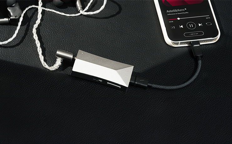 A Astell & Kern AK HC4 DAC and Amp plugged into a mobile phone and a pair of earphones