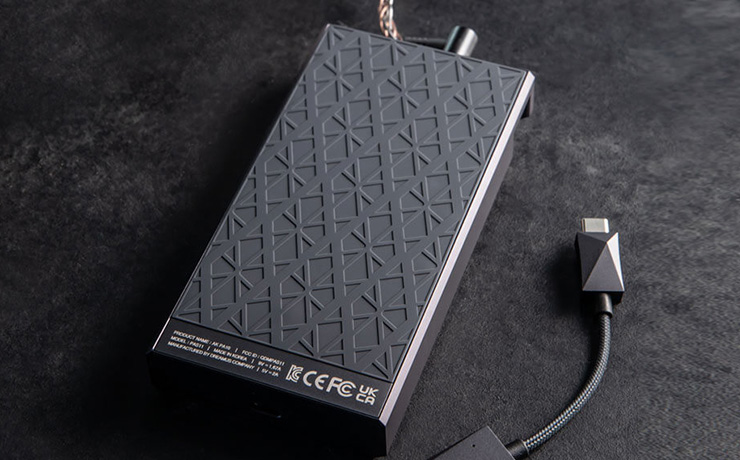 Astell & Kern AKPA10 Portable Class-A Amplifier laying on a soft surface