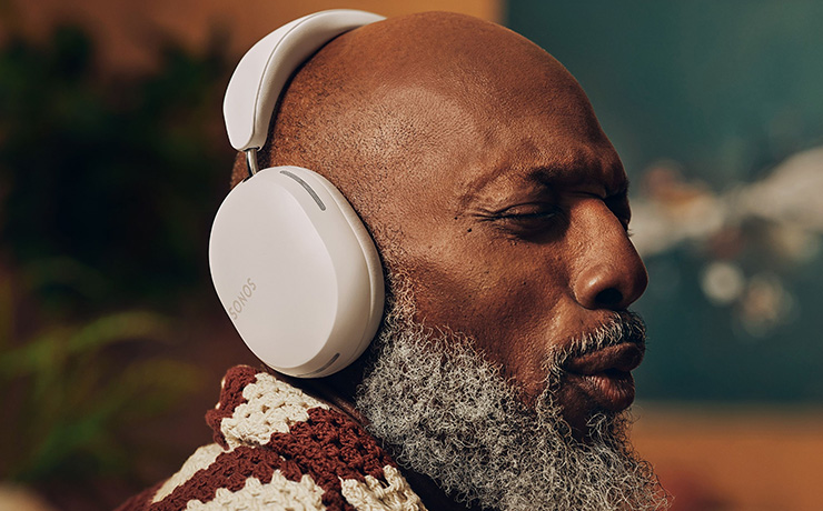 A man wearing the white Ace headphones and facing to the side.