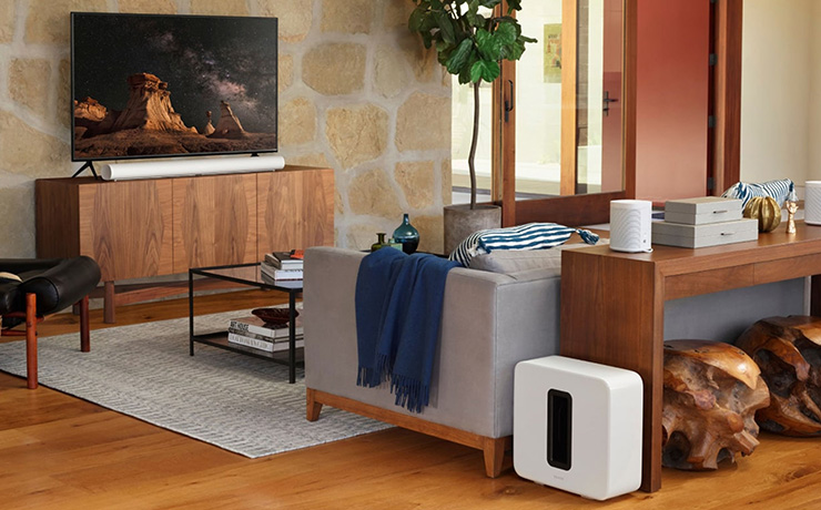 The SONOS Arc in a living space along with other SONOS products.  the Arc is in front of a tv