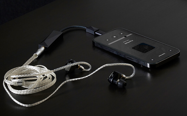 a mobile phone connected to an A&K HC3 and a pair of earphones