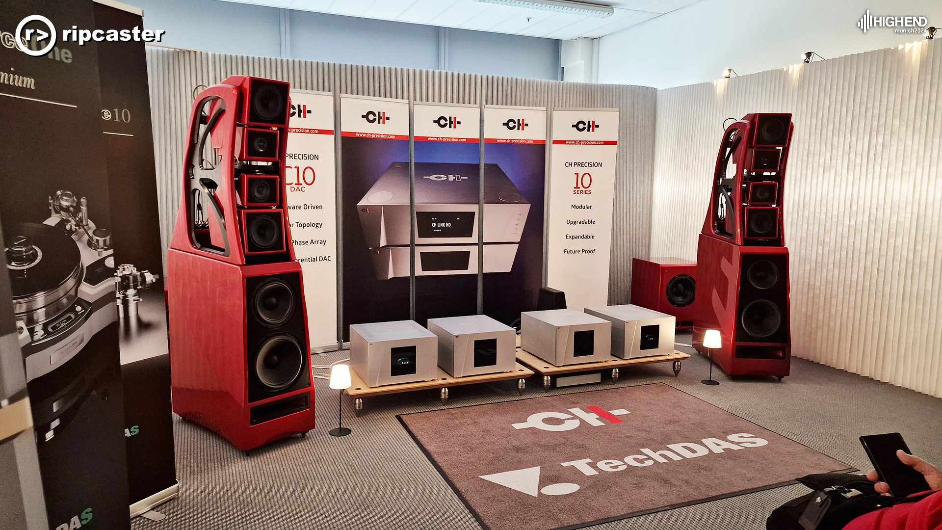 A pair of large red floorstanding speakers with HiFi kit between