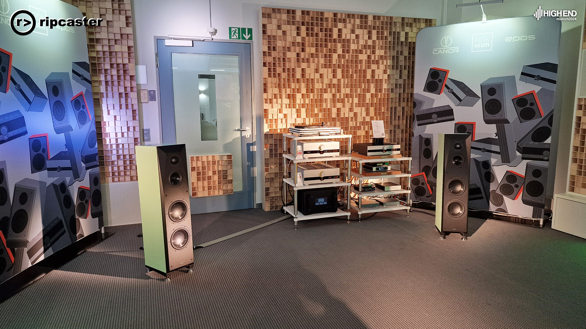 A pair of black and white floorstanding speakers with various HiFi kit between them.