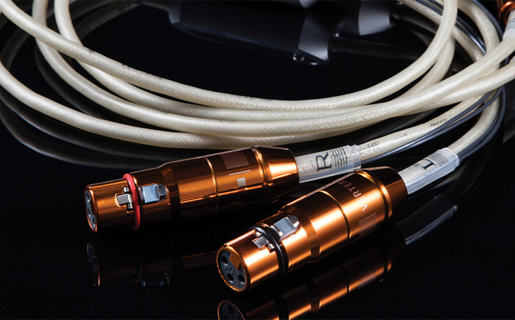 Vertere Pulse HB Loudspeaker cable showing the cable and connectors which are a copper colour.  All on a black background.