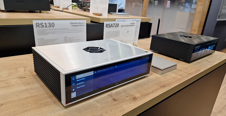 HiFi Rose RS130 Network Streaming Transport in silver on a wooden table beside a black RSA720 