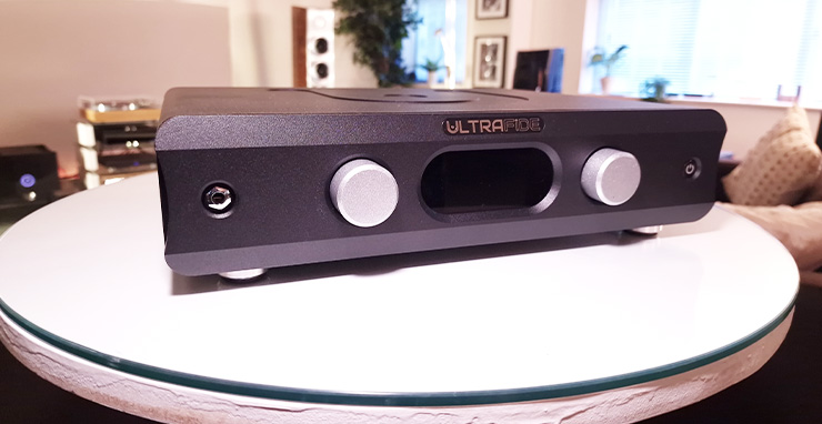Ultrafide U4PRE Audiophile Pre-Amplifier on a white table.  There are other HiFi items in the background