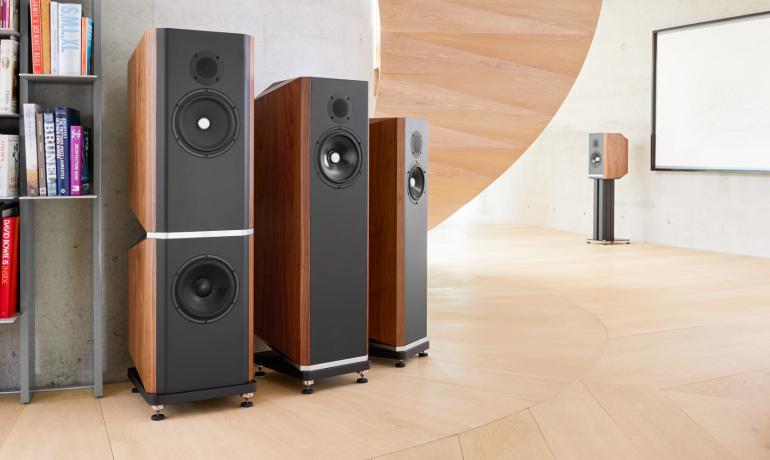Image shows all four Titan speakers: 505, 606, 707 and 808 in a large room with a book shelf to the side.