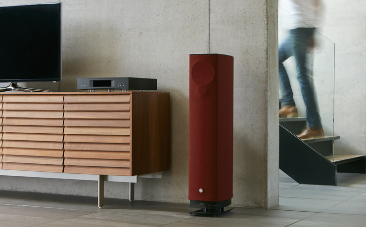 Linn 530 Loudspeaker beside a living room sideboard and a person walking upstairs in the background.