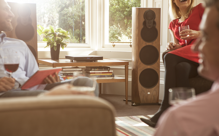 Linn Klimax 350 speaker in a living room with people chatting and drinking wine.