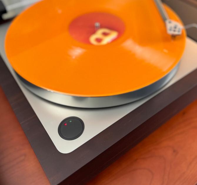 Linn Sondek LP12-50 Turntable view of the power button.  There's an orange record on the turntable.