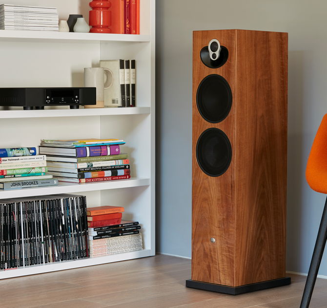 Linn Majik 140 Loud Speaker in a living room next to white shelves.