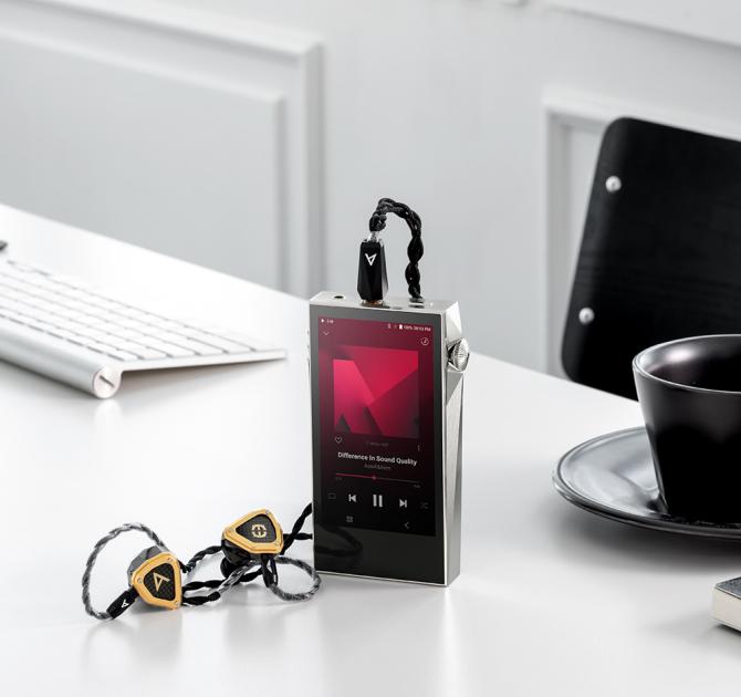 A&K SP3000M in copper nickel standing up on a table with plugged in earphones
