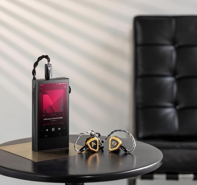 Astell & Kern A&ultima SP3000M Portable Music Player on a table with earphones beside it