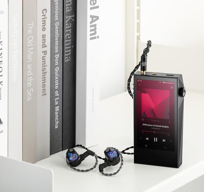 Astell & Kern A&ultima SP3000M Portable Music Player on a table with earphones beside it