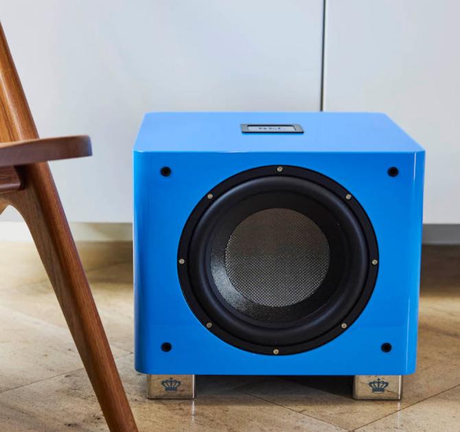 The REL T9x special edition in blue on a wooden floor beside a wooden chair