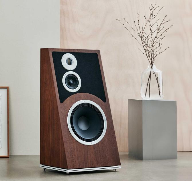 Audiovector Trapeze Ri in walnut with a glass vase on a small table