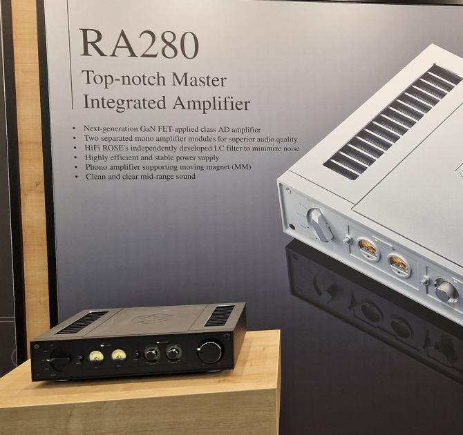 HiFi Rose RA280 in black on a wooden table with a backdrop of key features of the product.  Photo taken at the Munich HiFi show in 2024
