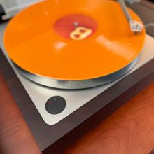 Linn Sondek LP12-50 Turntable view of the power button.  There's an orange record on the turntable.