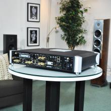 MOON 791 Network Player/Preamplifier on a table in the ripcaster showroom.  An Audiovector floorstanding speaker is in the background along with a tall indoor plant