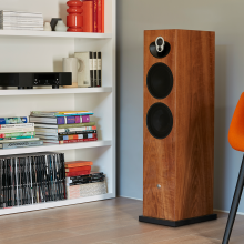 Linn Majik 140 Loud Speaker in a living room next to white shelves.