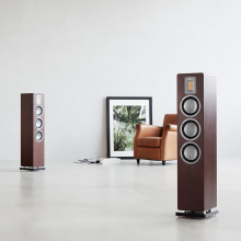 Audiovector QR5 pair in dark walnut with a chair and picture.