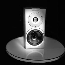 Audiovector R1 Arreté in black and white on a white glass topped table.  The photo was taken at the ripcaster showroom.