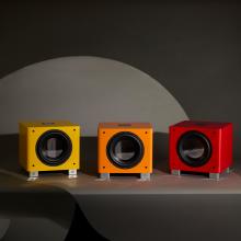 Three REL T/9x Special Edition Subwoofers - one red, one orange and one yellow