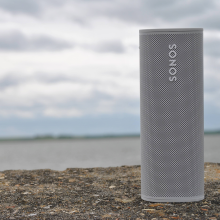 SONOS Roam in white standing up on the sea wall