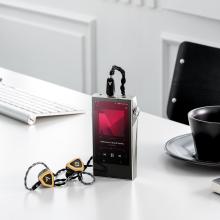A&K SP3000M in copper nickel standing up on a table with plugged in earphones
