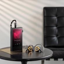 Astell & Kern A&ultima SP3000M Portable Music Player on a table with earphones beside it