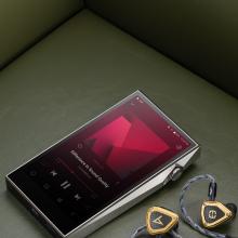 Astell & Kern SP3000T Portable Music Player laying on a sofa with some earphones beside it