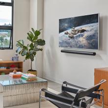 SONOS Arc Ultra Smart Soundbar in black on a wall underneath a tv screen