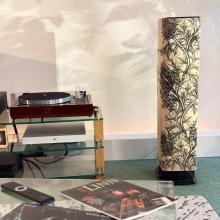 One of the ripcaster Linn 530 Thistle speakers with an LP12 beside it and an album and a remote control in the foreground