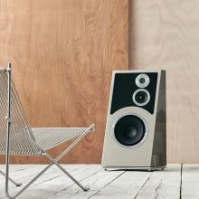 Audiovector Trapeze Ri in a custom finish facing a metal chair